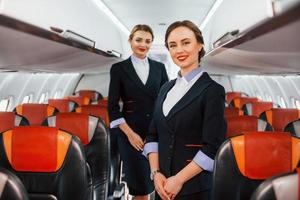 dos azafatas en el trabajo en el avión de pasajeros foto