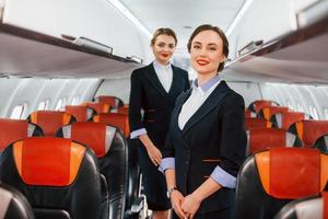 dos azafatas en el trabajo en el avión de pasajeros foto