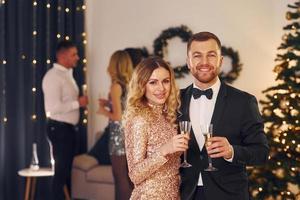 Young couple. Group of people have a new year party indoors together photo