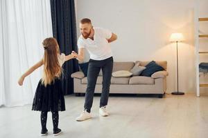 Learning to dance. Father with his little daughter is at home together photo