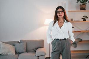 Business woman in formal clothes is indoors posing for the camera photo