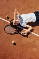 View from above. Female tennis player is on the court at daytime photo