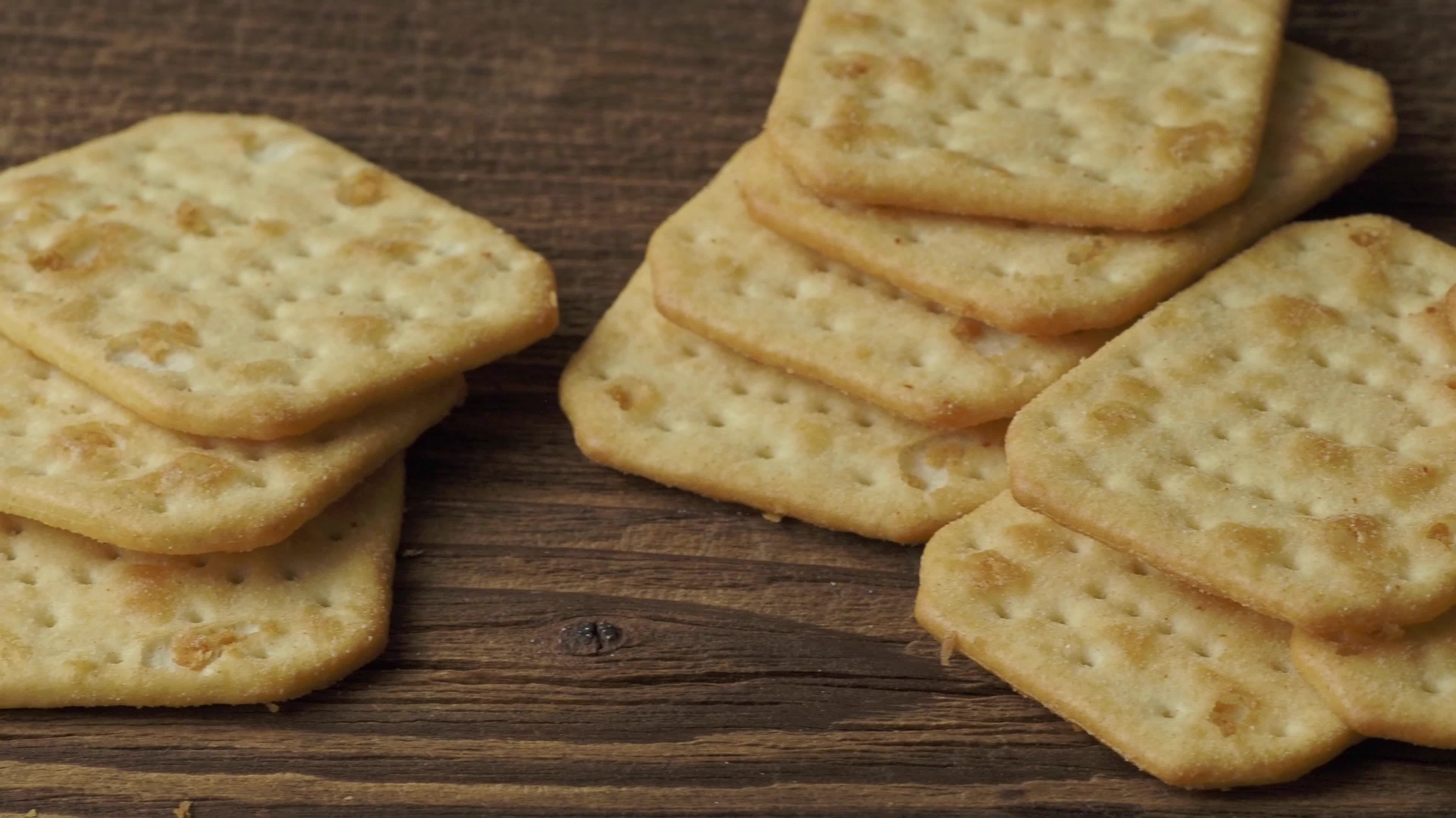 Delicious dry crackers on a wooden table. Biscuits salty crackers. 16732061 Stock Video at Vecteezy