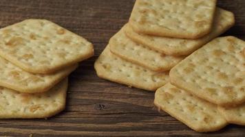 Delicious dry crackers on a wooden table. Biscuits salty crackers. video