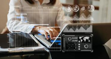 Businessman hand Project manager working and update tasks and Gantt chart scheduling virtual diagram.with smart phone, tablet and laptop in office. photo