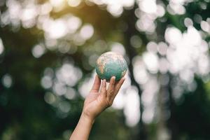 planeta verde en tu mano salva la tierra. concepto de ahorro de energía y medio ambiente. a la luz del sol foto