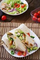 Fresh tortilla wraps with chicken and fresh vegetables on plate photo