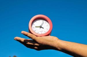 concepto de tiempo con la mano sosteniendo un reloj foto