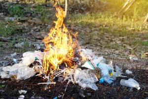 fuego quema montón de basura. concepto, incineración de residuos domésticos, papel, cartón, restos de comida, plástico, ramitas y otros residuos que provocan la contaminación del aire. manejo de basura foto