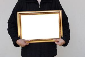 el hombre de primer plano sostiene un marco de fotos vacío o un marco de certificado de diploma en blanco. copie el espacio para agregar texto o fotos. concepto, orgullo, recuerdos y nostalgia.