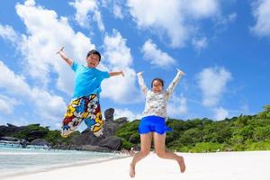 padre e hija saltando en la playa en tailandia foto