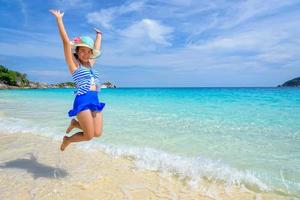 Girl jumping with happy on the beach at Thailand photo