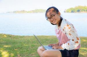 Young girl with laptop on the grass photo