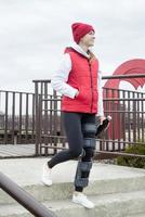 Woman wearing knee brace or orthosis after leg surgery, walking in the park photo