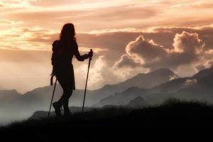 trekking en soledad entre las montañas. silueta de una niña foto