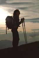 una chica solitaria con su mochila descansa y observa el panorama durante una peregrinación religiosa foto