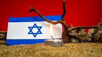 Israeli flag and candles burning in front of it, Holocaust memory day photo