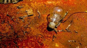 Light bulb on rusty zinc as a background photo