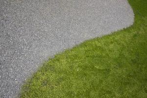 Curved lines of green lawn and asphalt, for the background. Copy space. Top view. photo