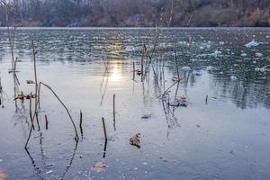 View of the ice surface of a draught frozen lake during the day photo