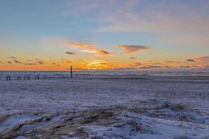 puesta de sol en la playa de invierno de balvand en dinamarca foto
