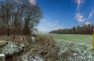 Image of a stream flowing through a winter forest photo