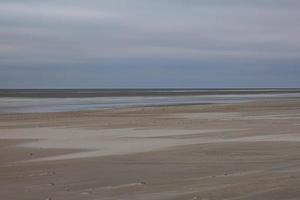 View of wide sandy beach of Vejers in Denmark in evening light photo