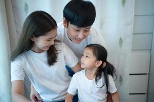 Family vacation, father and mother helping daughter practice in her piano lessons photo