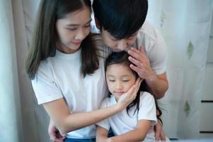 Family vacation, father and mother helping daughter practice in her piano lessons photo