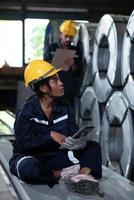 Young female engineer learning to run machinery at a factory with veteran engineers photo