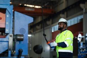 enormes máquinas y materiales se encontrarán en una gran fábrica industrial. como resultado, la transferencia requiere el empleo de una grúa foto