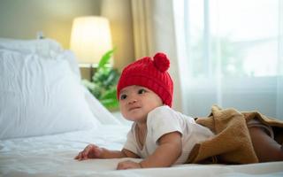 Newborn baby wearing red hats In the white bedroom, warm sunlight in the evening of the day photo