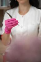 Uno spoons in the hands of a cosmetologist, tools of a cosmetologist for cleaning the face. photo