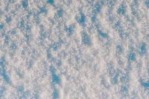 fondo de nieve invernal, cristales de hielo que brillan en la nieve, textura navideña, copos de nieve brillantes en la nieve. foto