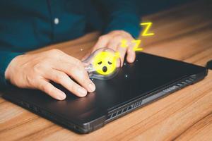 Man put a glowing a light bulb wiht sleepy icon on a wooden table, business problem solving ideas and creative marketing ideas Inventing and learning new things. photo