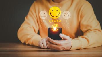 Man using a mobile phone in give rating to service experience on application. Online customer review satisfaction feedback survey and testimonial. photo