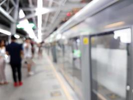 muchas personas hacen cola para esperar el tren aéreo, desdibujan el fondo foto