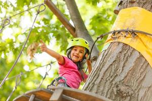 happy little children in a rope park on the wood background photo