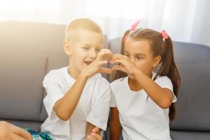 niño y niña hacen un corazón foto