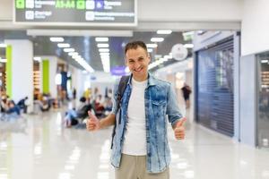 portrait of a happy male traveler walking with backpack photo