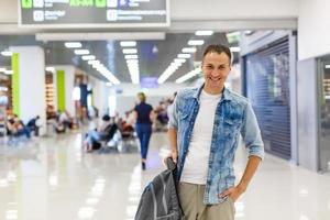 portrait of a happy male traveler walking with backpack photo