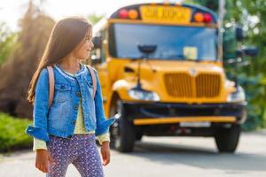 colegiala está esperando un autobús escolar foto