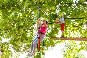 happy little children in a rope park on the wood background photo