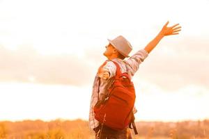 Getting away from it all. Man in open field relaxing looking at the beautiful view. photo
