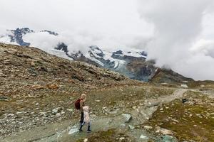 madre e hijos paseando por un entorno montañoso foto