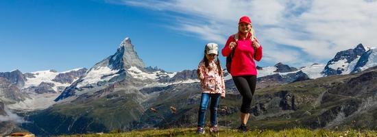 Happy hiker woman and girl at mountains lake photo