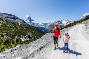 Happy hiker woman and girl at mountains lake photo