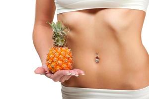 Beautiful female belly and pineapple on white background photo