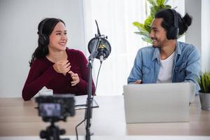 Asian female and male podcaster making audio podcast in home studio, DJ and radio online concept