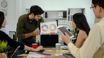 concepto de equipo creativo y creador, grupo de jóvenes que se reúnen y verifican el gráfico de papel de color para el diseño de trabajo, lluvia de ideas sobre el concepto de trabajador del diseñador foto